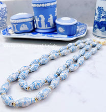 Load image into Gallery viewer, A blue Chinoiserie double strand necklace made of ginger jar shaped porcelain beads is laying flat beside some pieces of Wedgwood Jasperware.