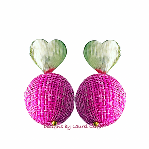 A pair of pink raffia ball earrings with gold heart posts 